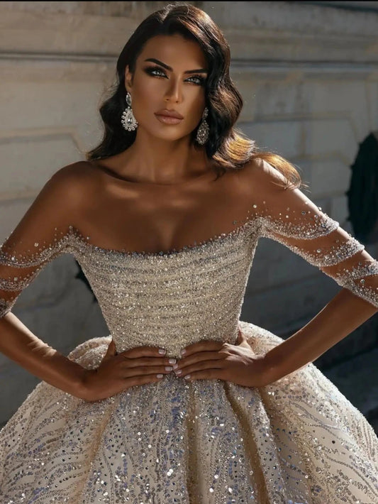 Vestido de novia de manga larga de cuello largo modesto con toques de novia brillantes.