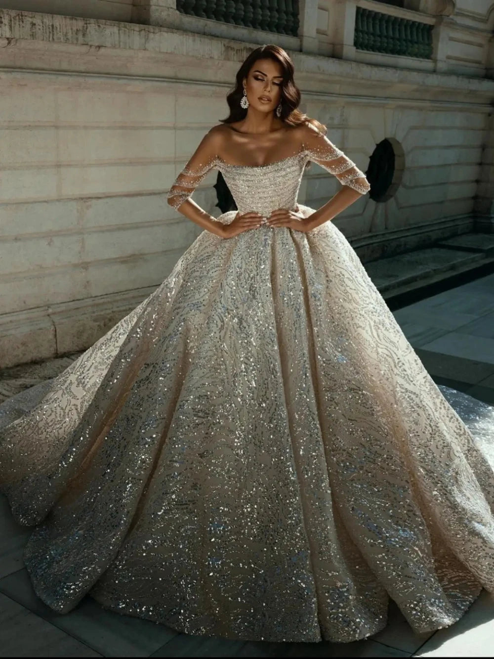 Vestido de novia de manga larga de cuello largo modesto con toques de novia brillantes.