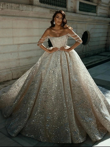 Vestido de novia de manga larga de cuello largo modesto con toques de novia brillantes.